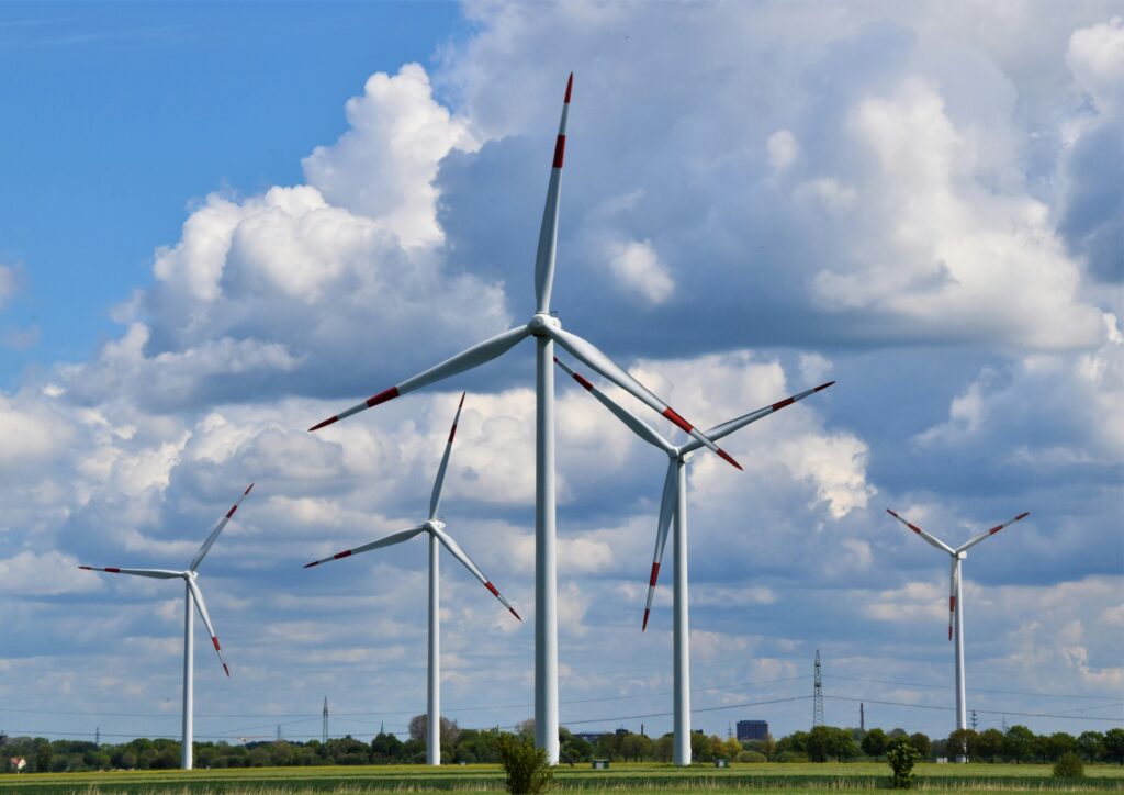 Wind turbine in a field with blue sky displaying the potential construction Industry Challenges